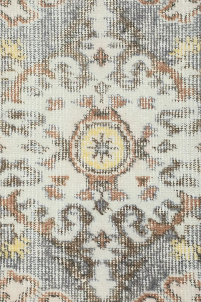 Close-up texture of the low wool pile, revealing the hand-knotted construction and distressed look.