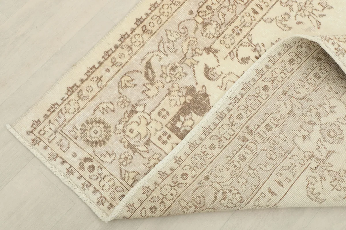 View of the rug folded to reveal the cotton foundation and the reverse side of the knotting.