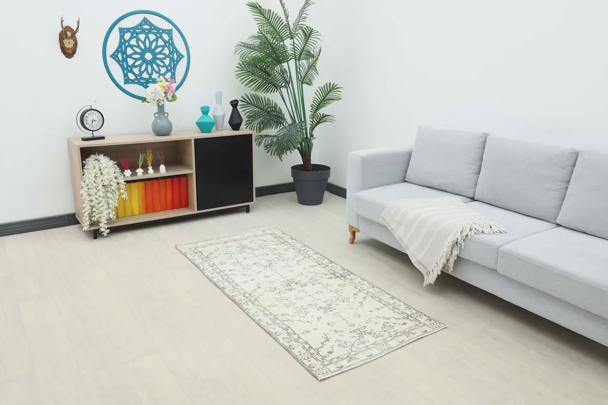 Ivory and gray runner rug placed in a modern living room setting with a light gray sofa