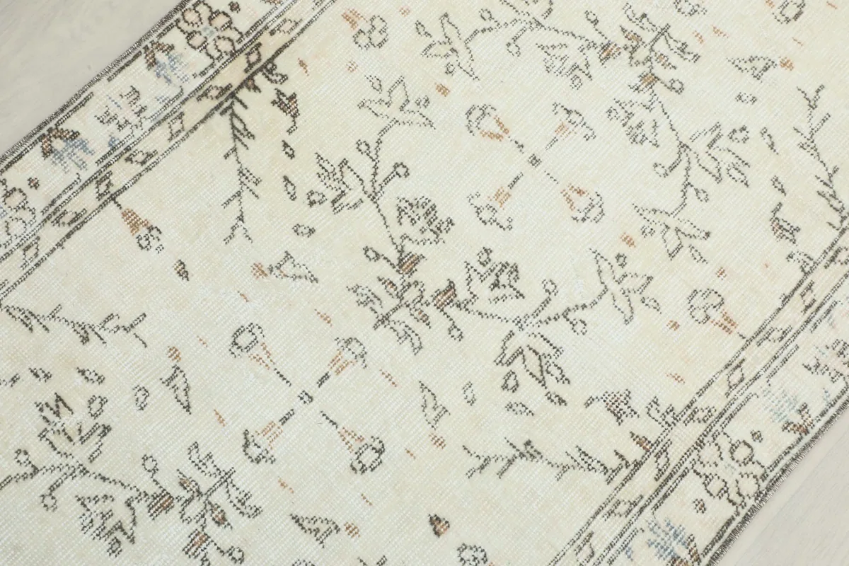 Detailed view of the central floral and geometric patterns on the ivory background