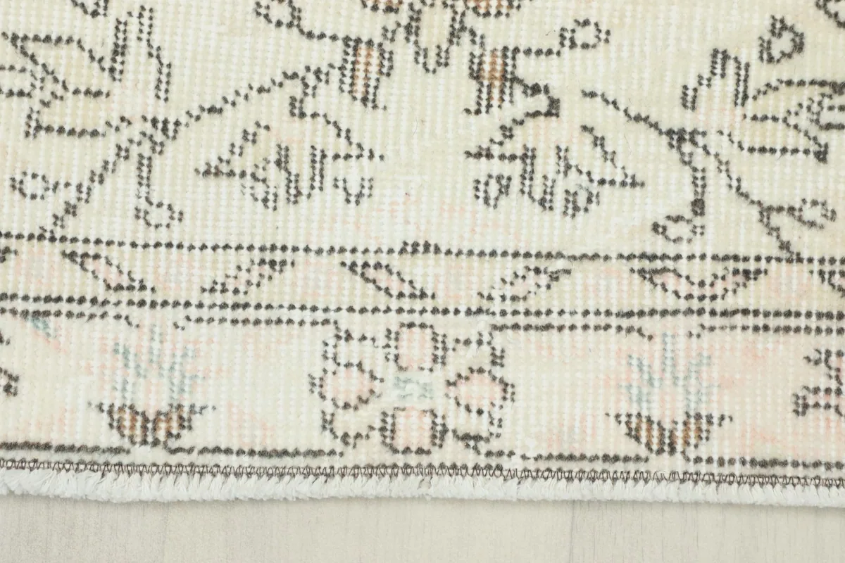 Detailed view of the rug's border, showing the patterned edge and short fringes
