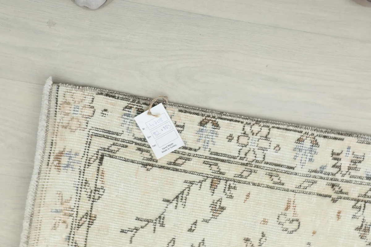 Close-up of the rug's corner with a product tag attached, showing construction and colors