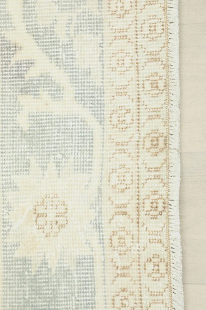 Detail of the rug's edge, showcasing the fringe and the hand-knotted construction