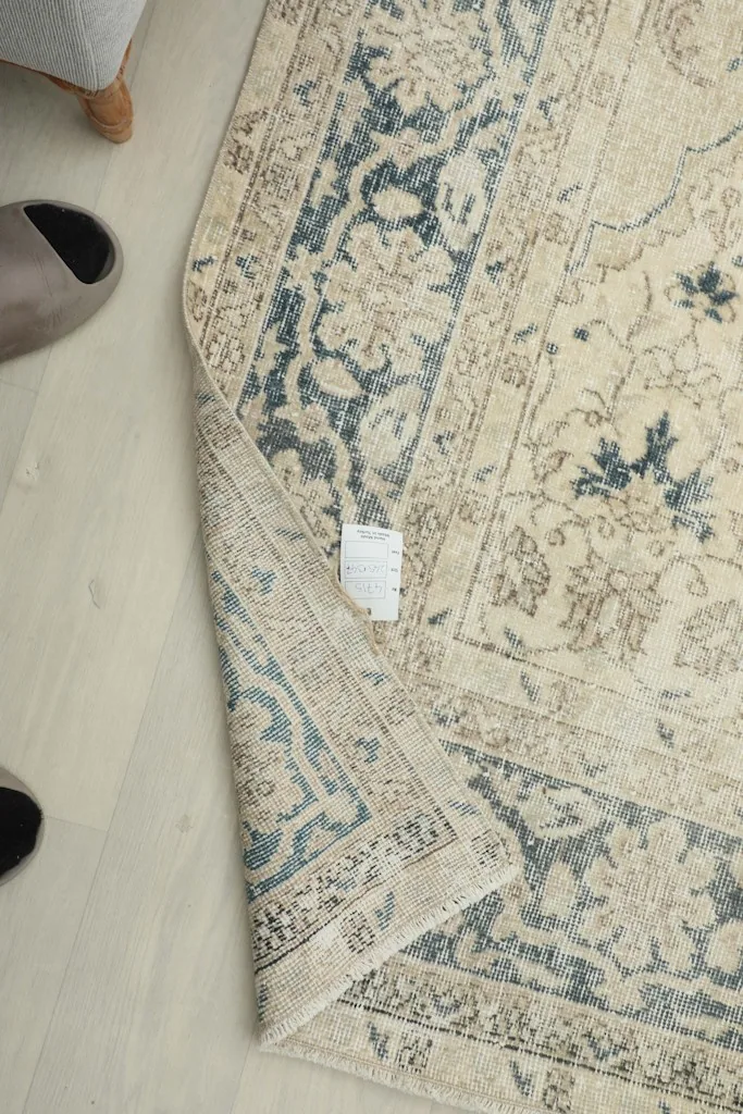 Close-up of the rug's reverse side with a label, showing the hand-knotted cotton foundation