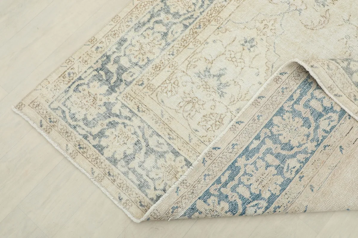 Corner of the rug folded back, revealing the reverse side and construction