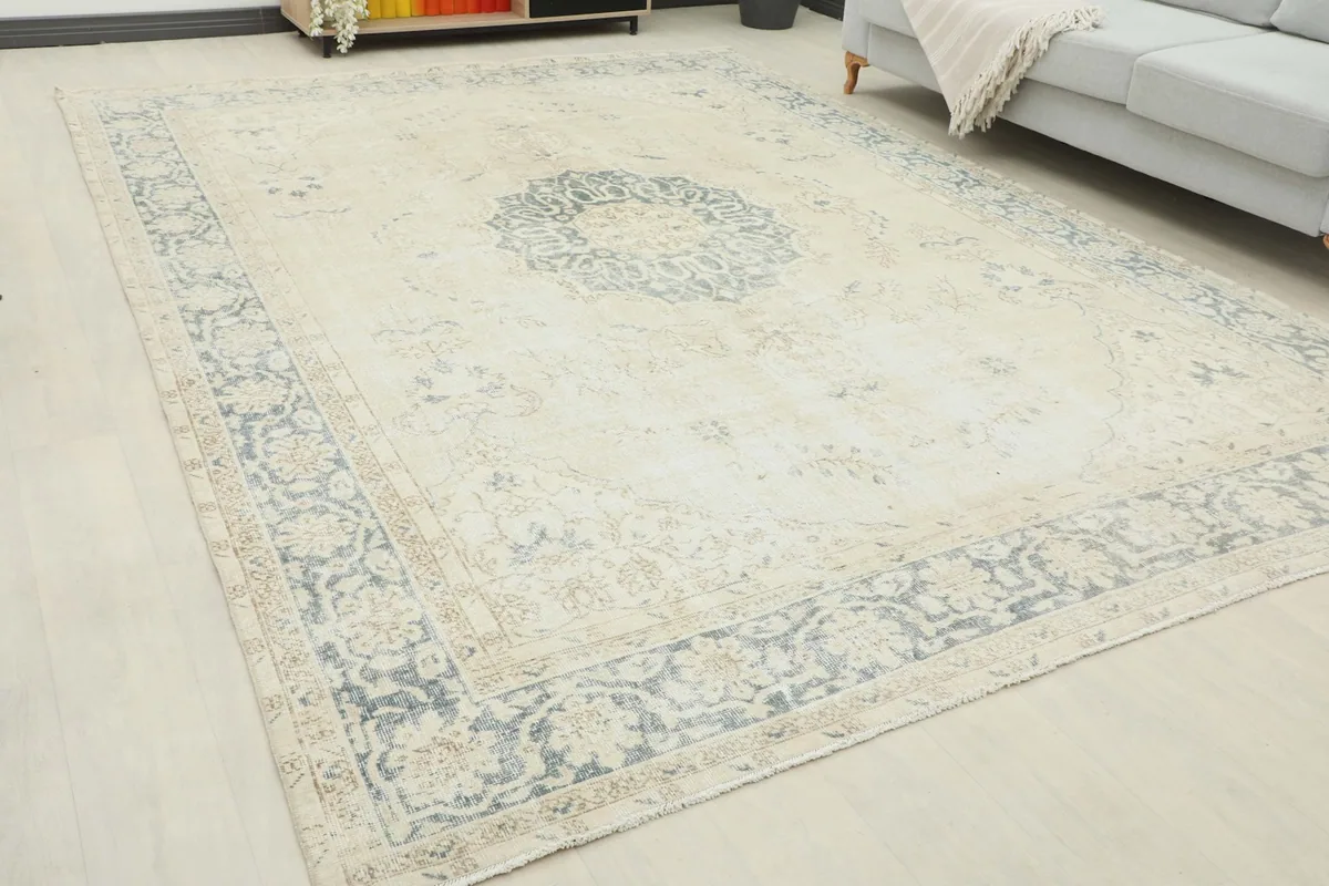 Overhead angled view of the large beige and gray vintage rug in a room