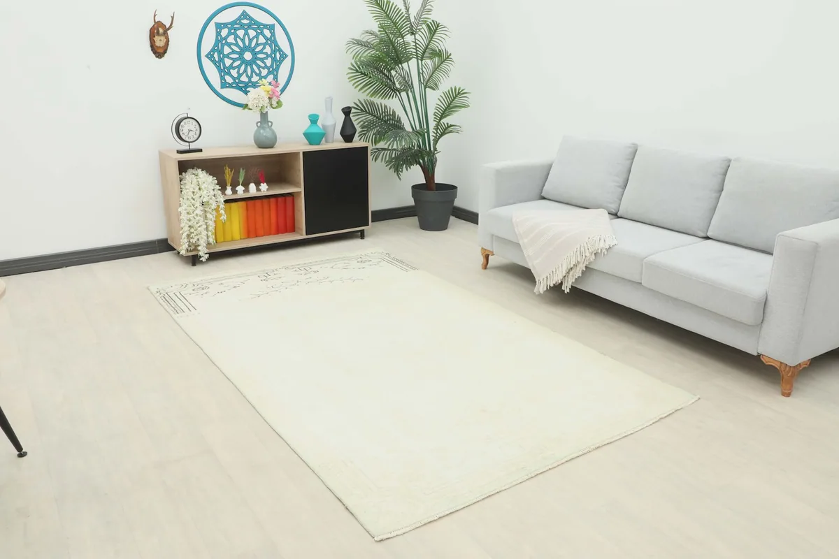 Ivory vintage rug displayed in a bright living room setup with a light gray sofa and wooden console.