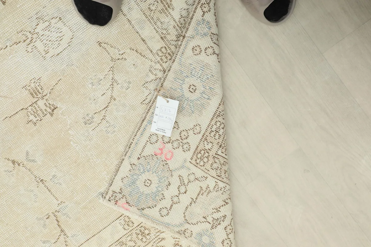 Close-up of the rug's corner with the product tag, showing the reverse side's weave.