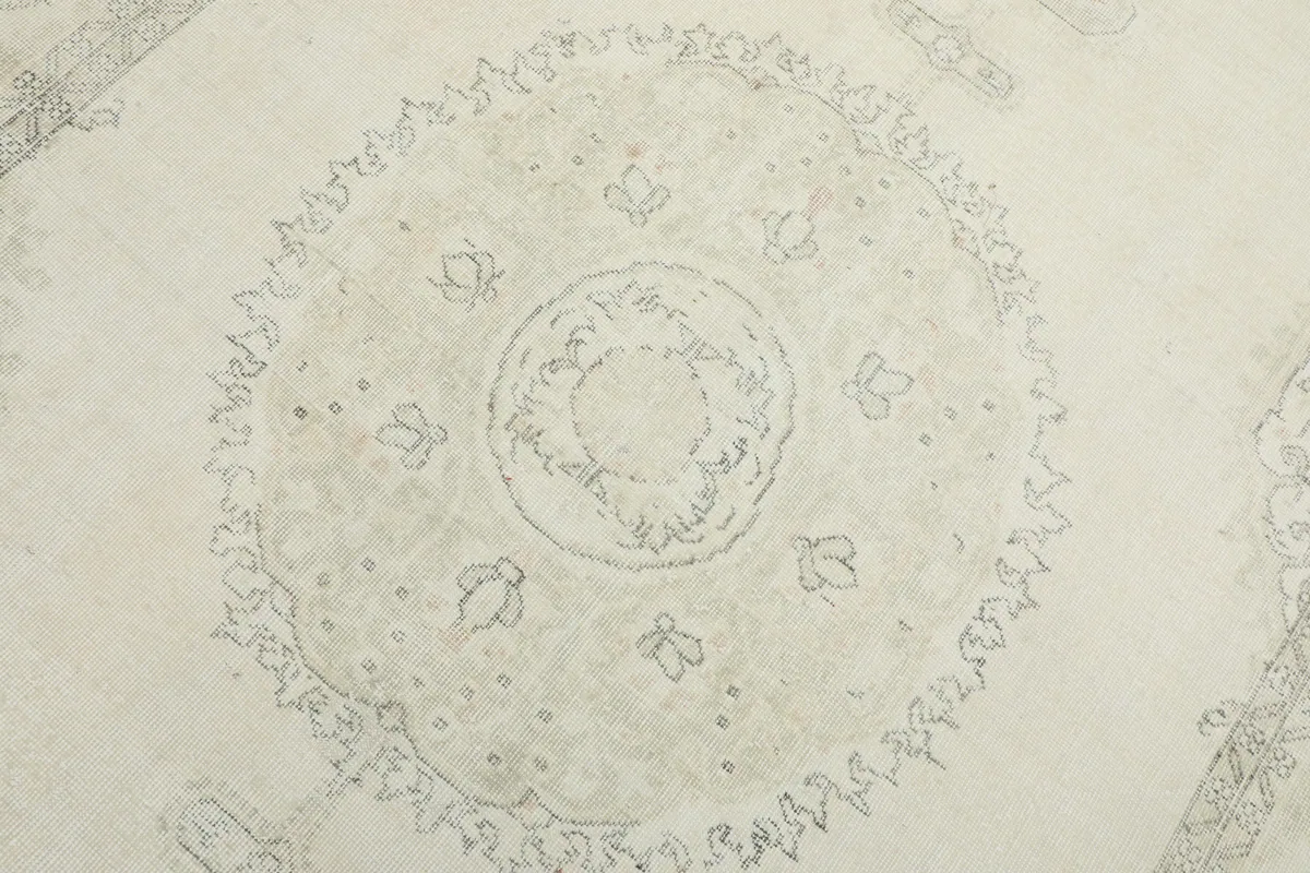 Close-up detail of the central medallion pattern in cream and gray tones.
