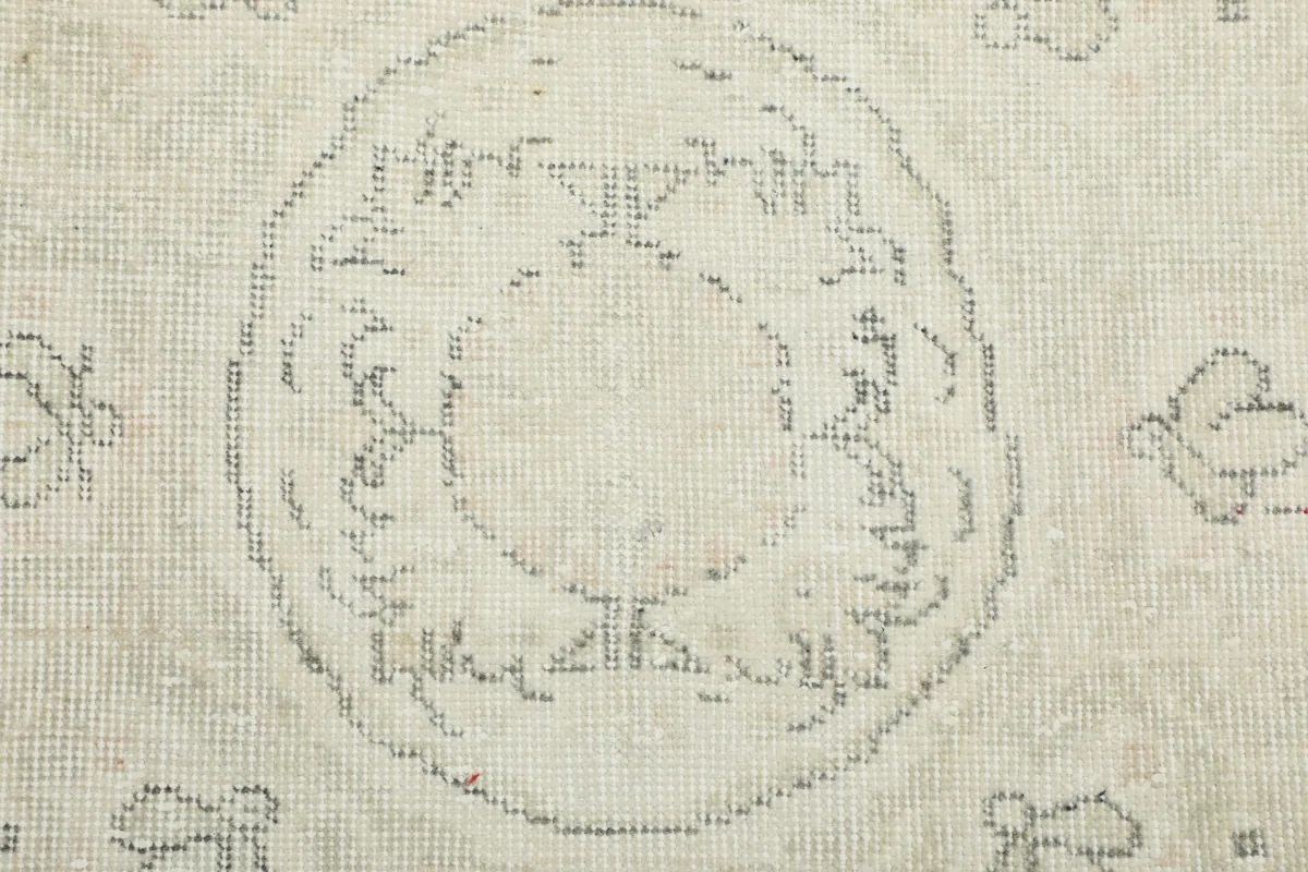 Detailed view of the hand-knotted texture and faded gray patterns on the rug.