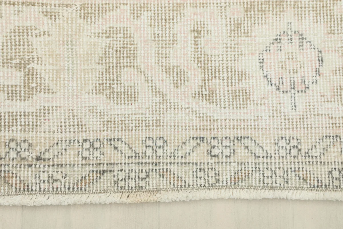 Close-up of the rug's border design and fringe, showing the low pile.