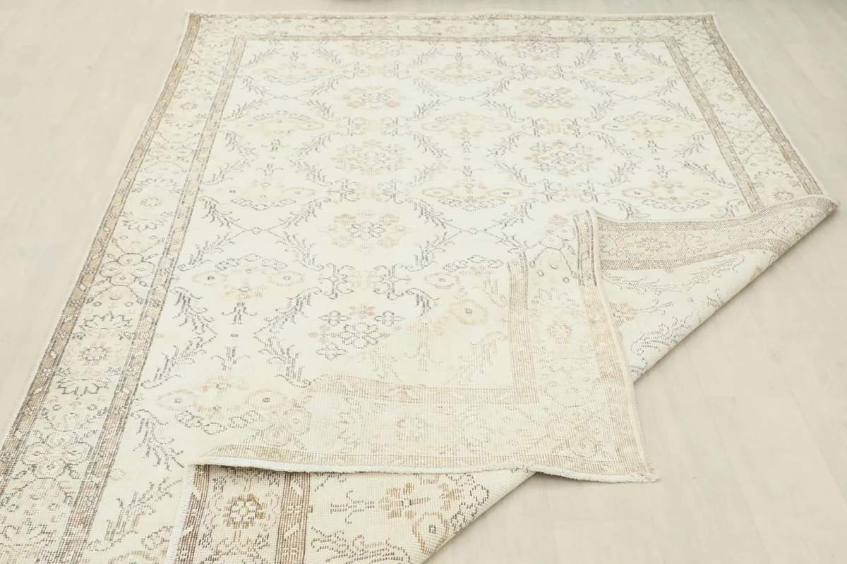 View of the rug's underside and folded edge, displaying the hand-knotted construction.