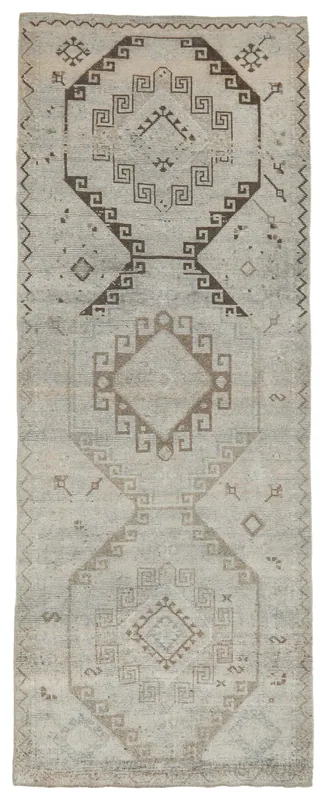 Full top view of the beige and brown tribal geometric vintage Anatolian runner rug on a white background.