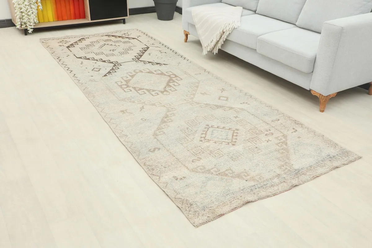Angled view of the beige tribal runner rug in a room, highlighting its geometric patterns.