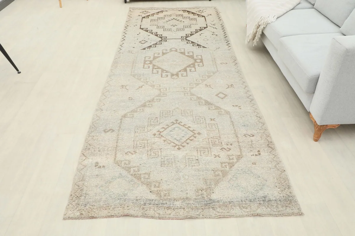 Full view of the beige tribal geometric runner rug laid out in a contemporary room setting.