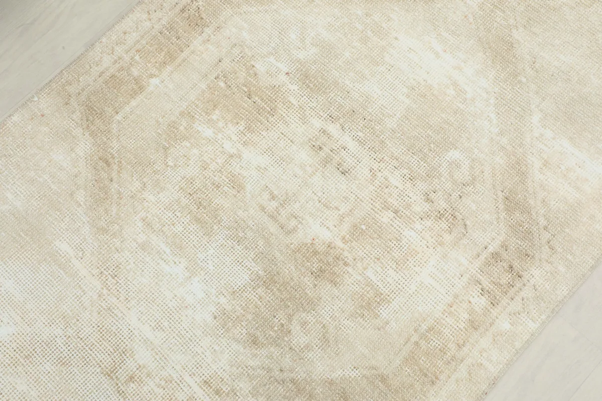 Overhead close-up of the central beige geometric medallion design and low pile texture.