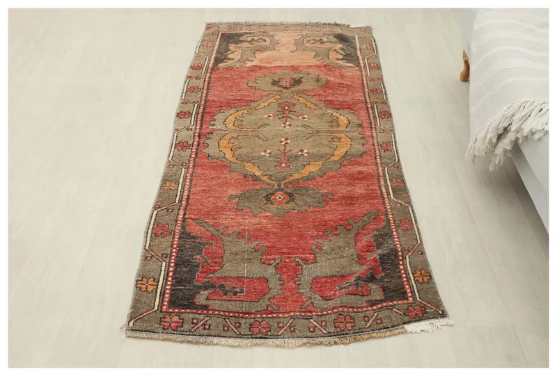 Full top view of the vintage rust Anatolian runner rug with a central medallion on a white background