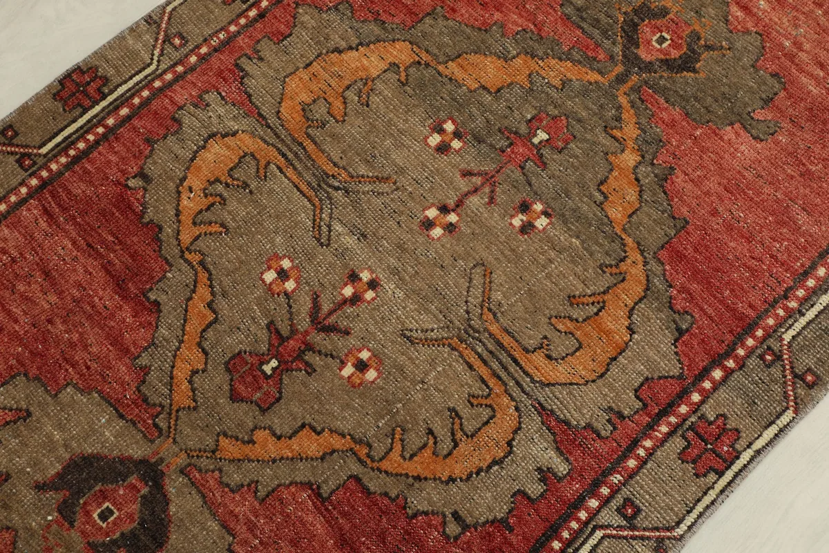 Detailed shot of the central medallion motif in beige, rust, and brown tones