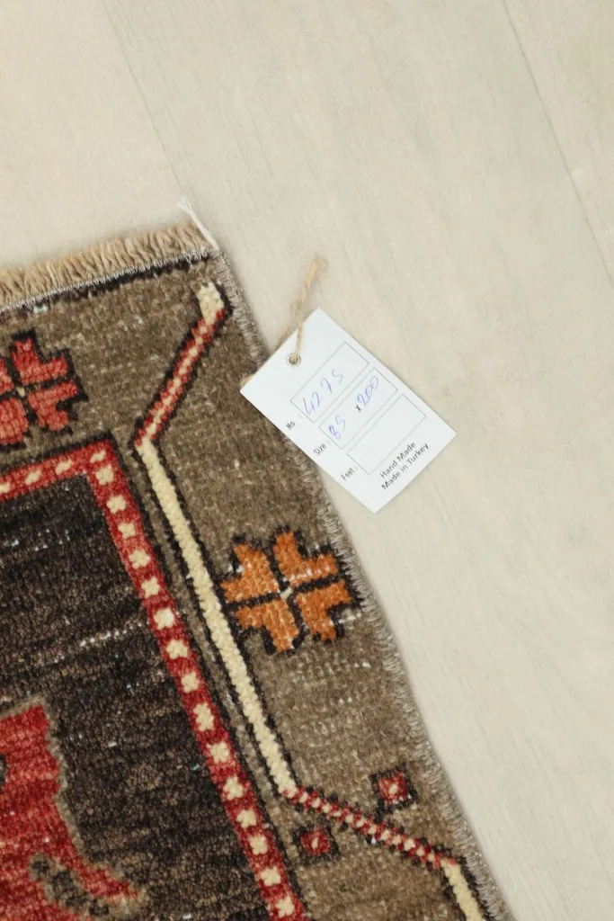 Corner of the rug with a tag displaying product information and dimensions