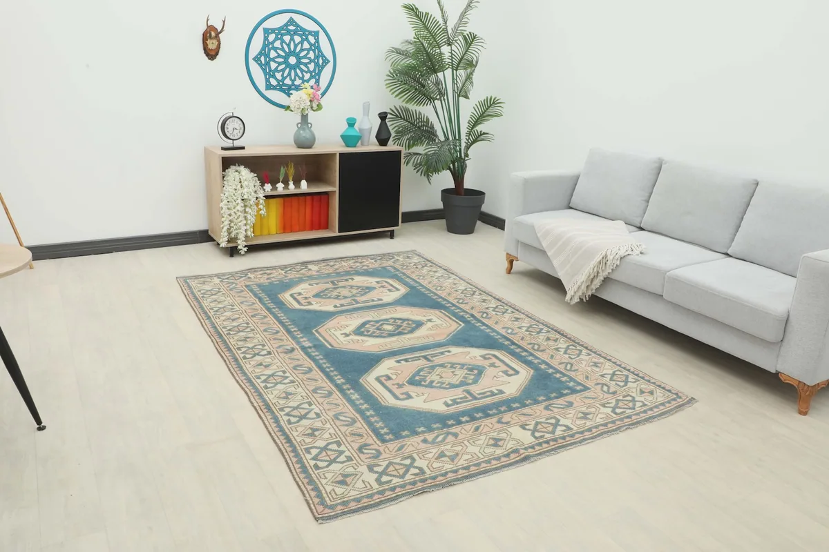 Vintage blue rug displayed in a living room setting with a light gray sofa