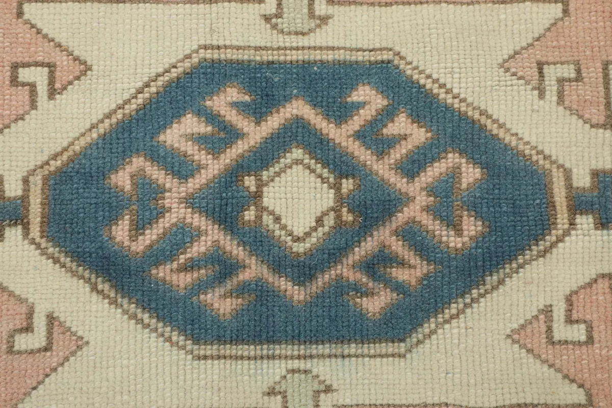 Detailed view of an ivory medallion with blue and rose geometric motifs