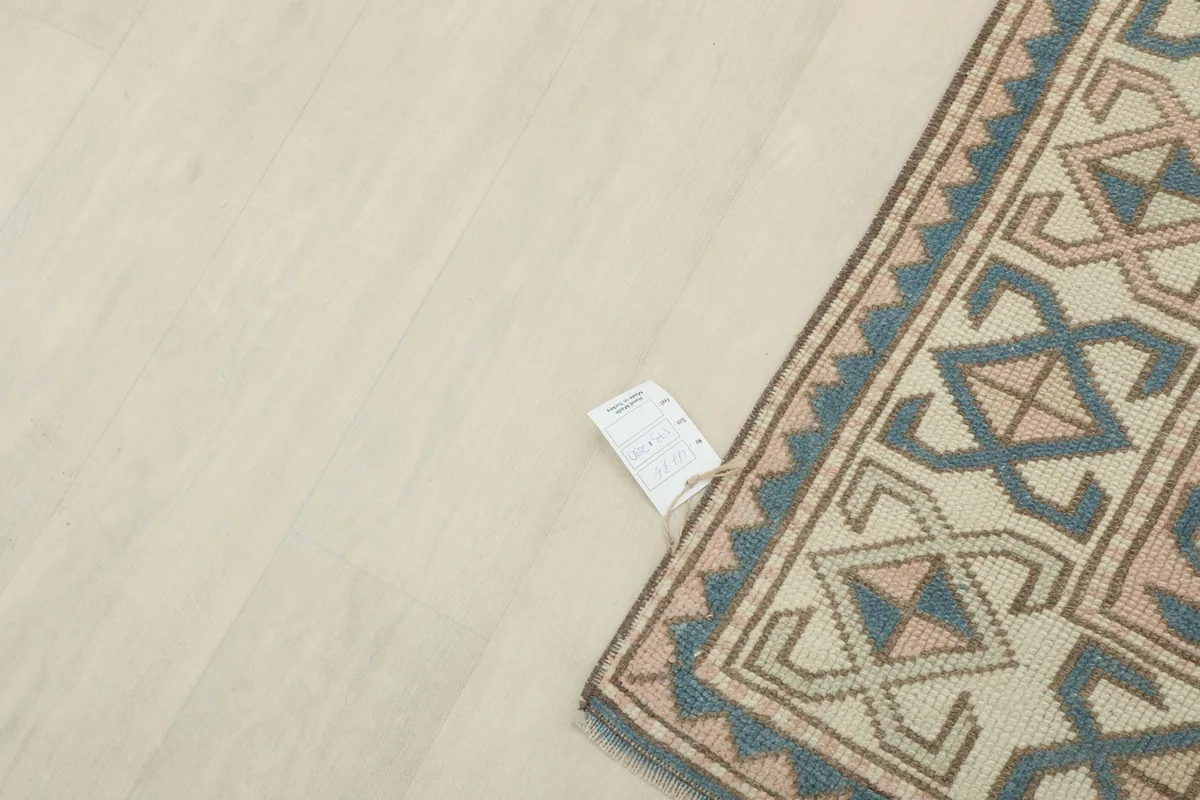 Corner of the rug with its product tag on a light floor