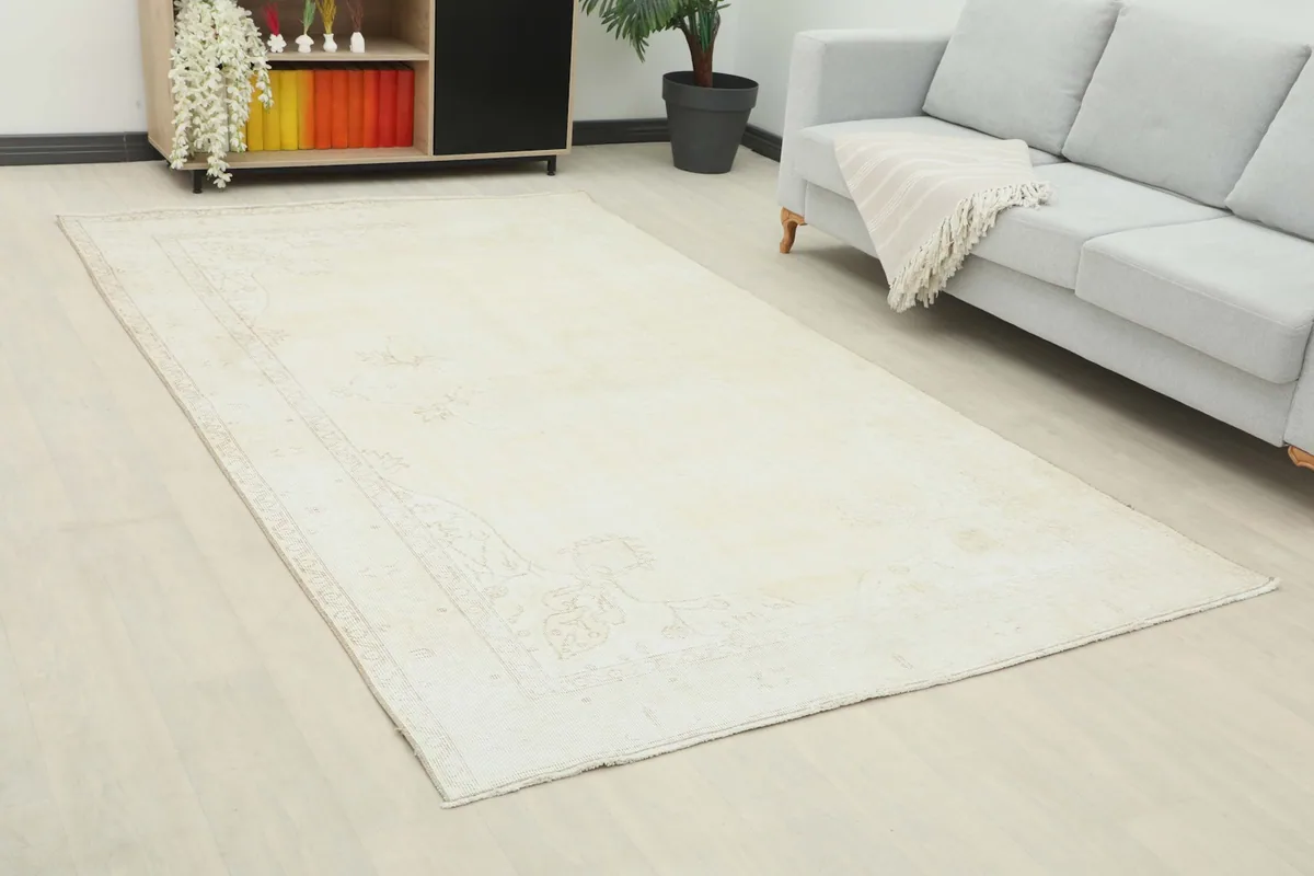 Angled view of the ivory area rug in a living space, highlighting its placement relative to furniture.
