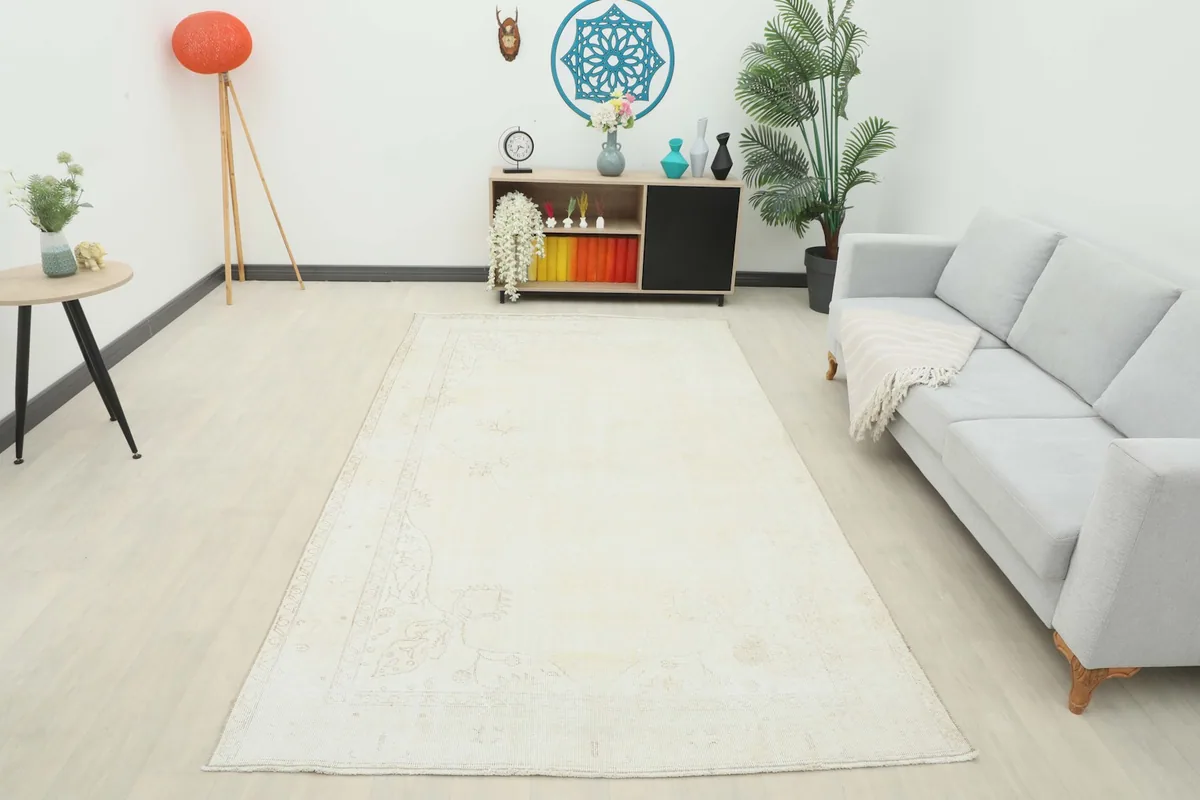 Wide shot of the ivory vintage rug in a styled room, offering a full perspective of its scale.