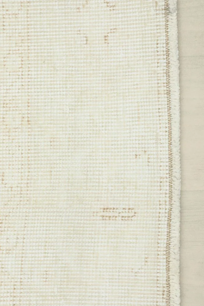 Underside view of the hand-knotted cotton foundation and wool knots of the vintage rug.