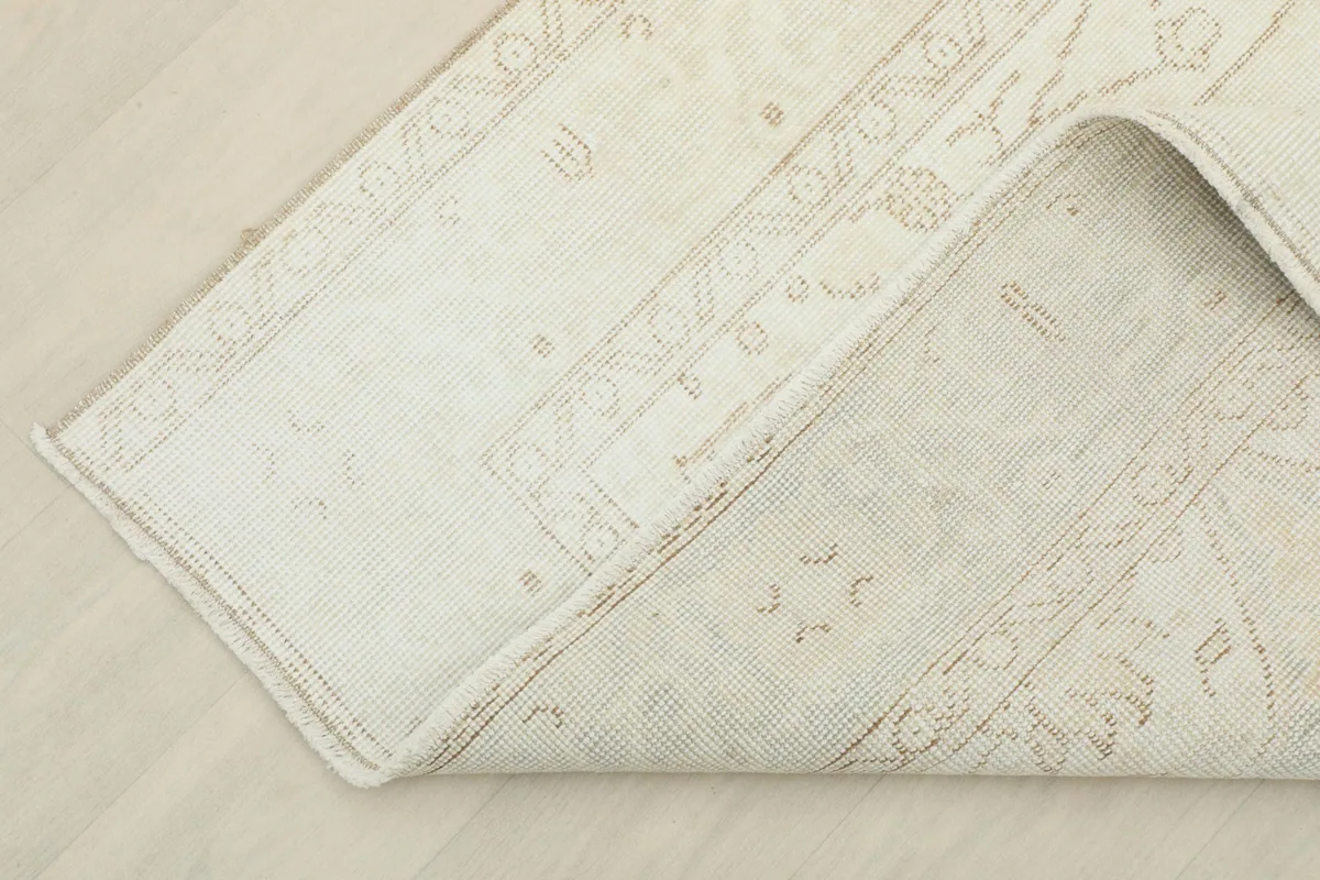 A folded section of the rug, revealing the thickness and the back of the textile.