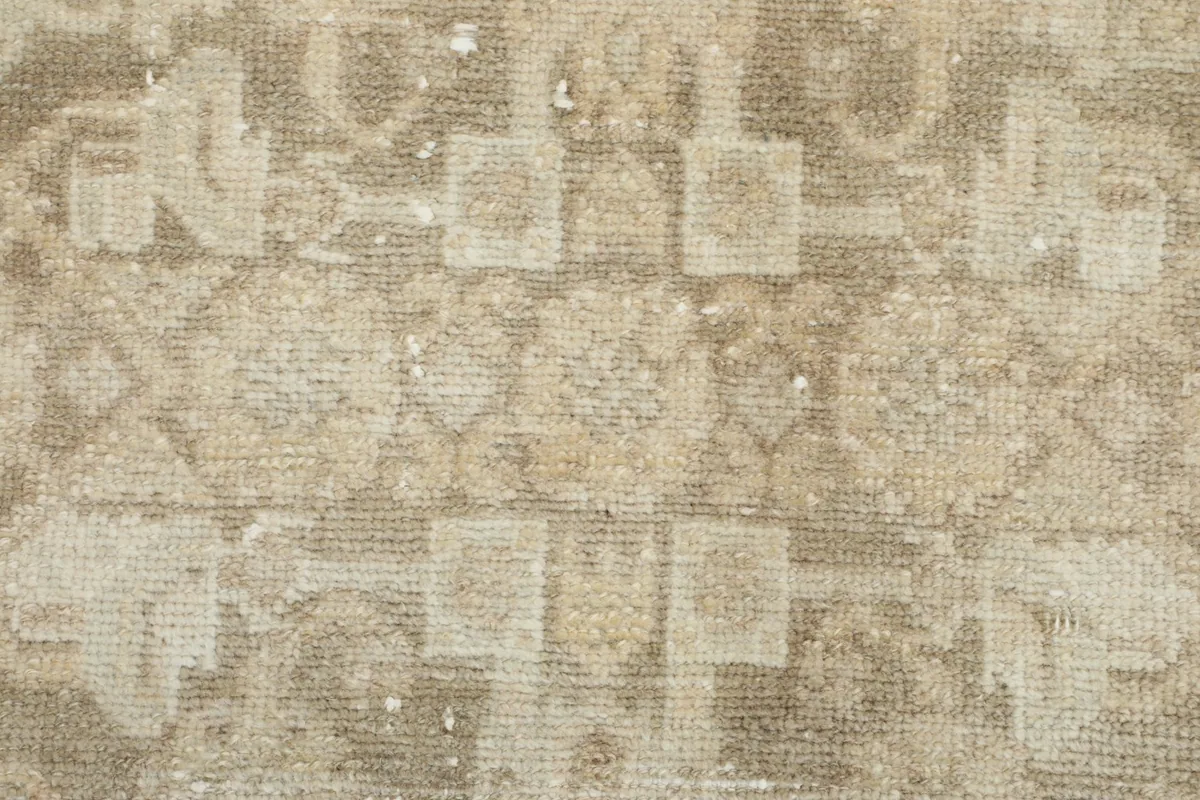 Detailed view of the low wool pile and the texture of the faded vintage rug surface.