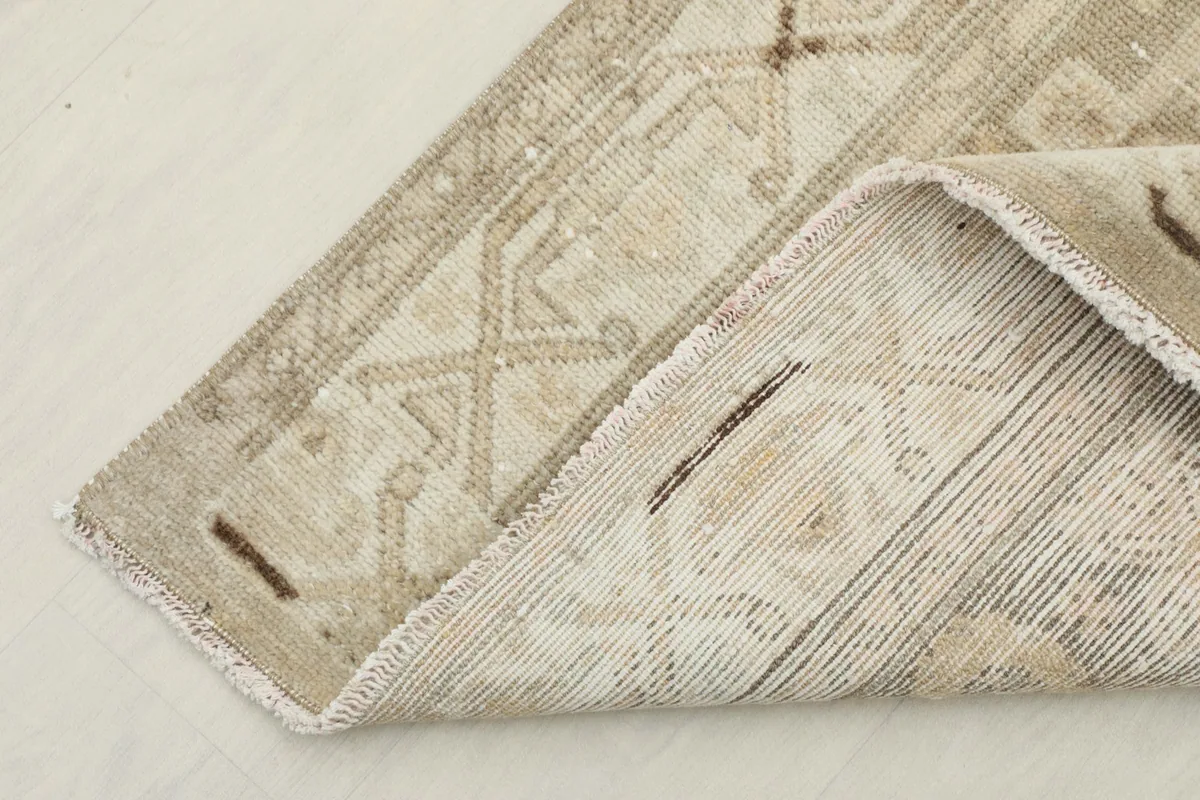 Corner view showing the reverse side of the hand-knotted wool pile on cotton foundation.