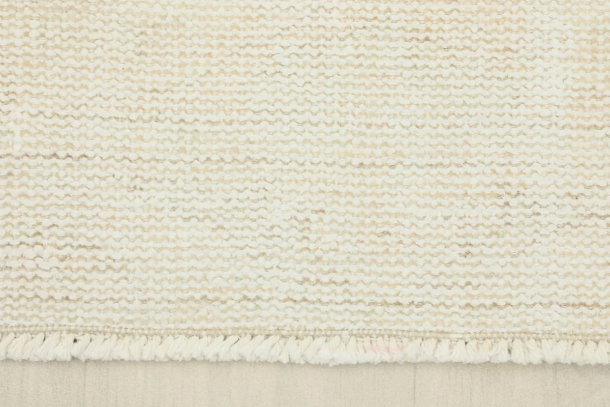 Close-up of the short, natural fringe and the woven edge of the ivory runner.