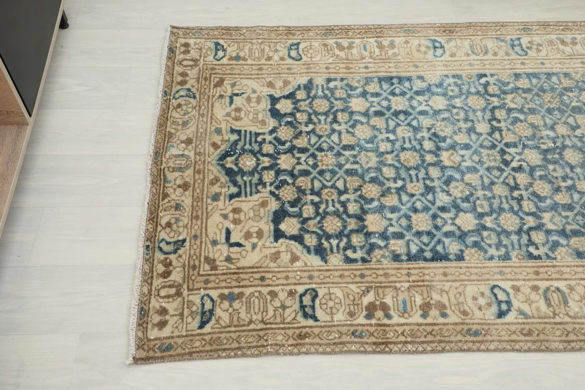 Angled view of the rug's top left corner, showing color variations and design