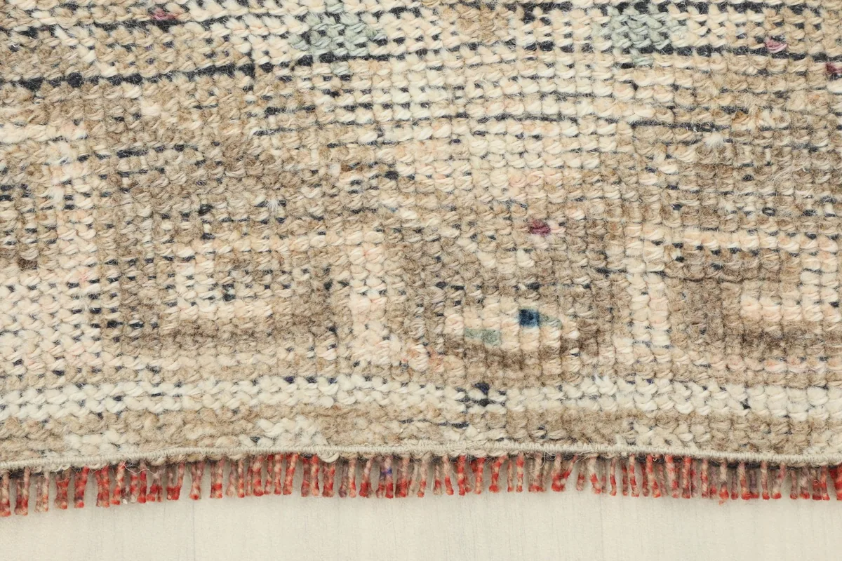 Detail of the short, textured fringes and the end border design of the runner