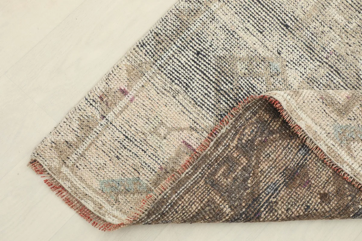 Corner of the runner folded to show the wool pile and cotton foundation texture