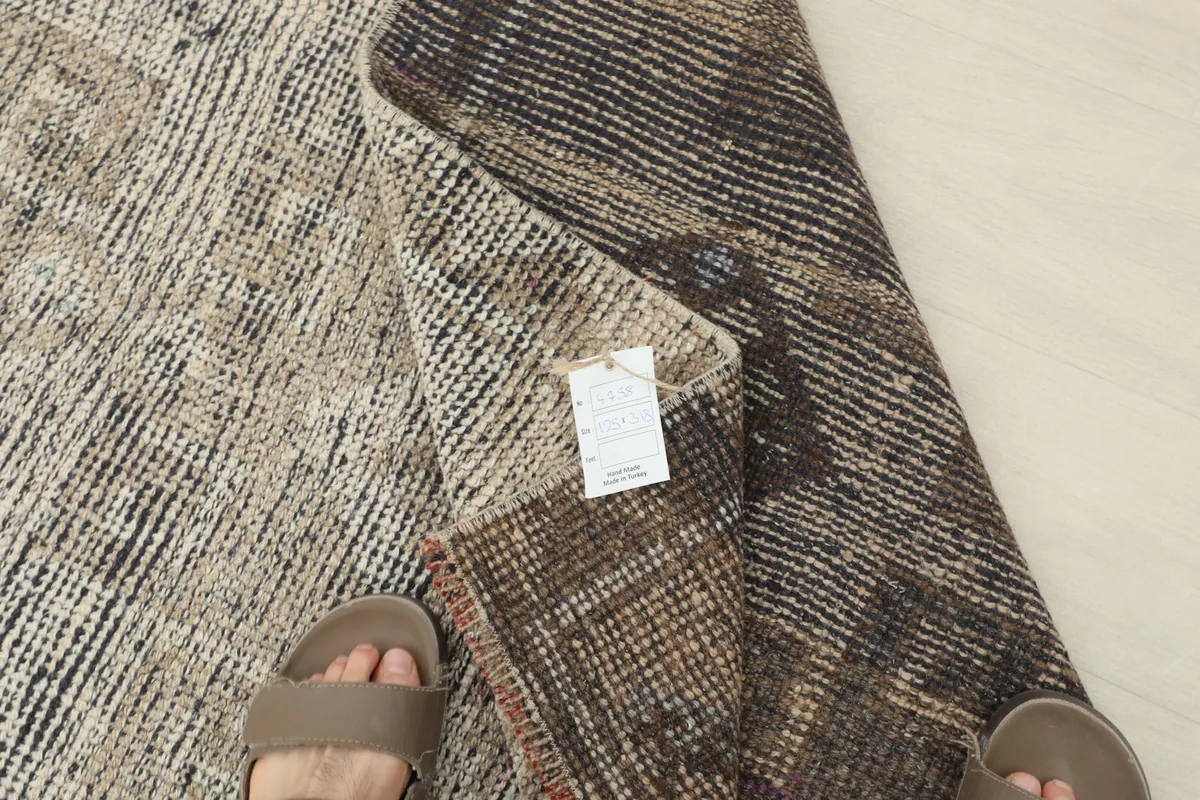 Close-up of the folded rug corner with the product tag, showing the reverse side and pile