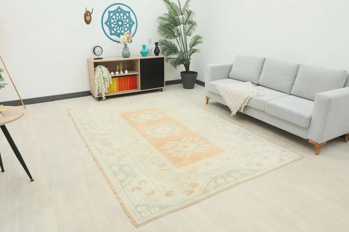Vintage Anatolian rug displayed in a bright living room setting with a gray sofa.