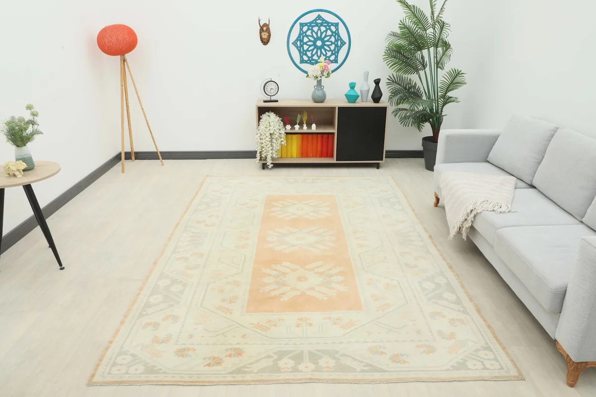 Full room view of the orange and ivory vintage rug, providing a sense of its scale and presence.