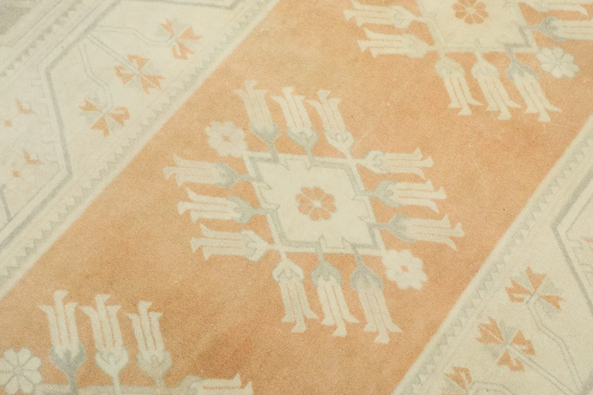 Detailed view of the central orange field with distinct ivory and gray floral geometric motifs.