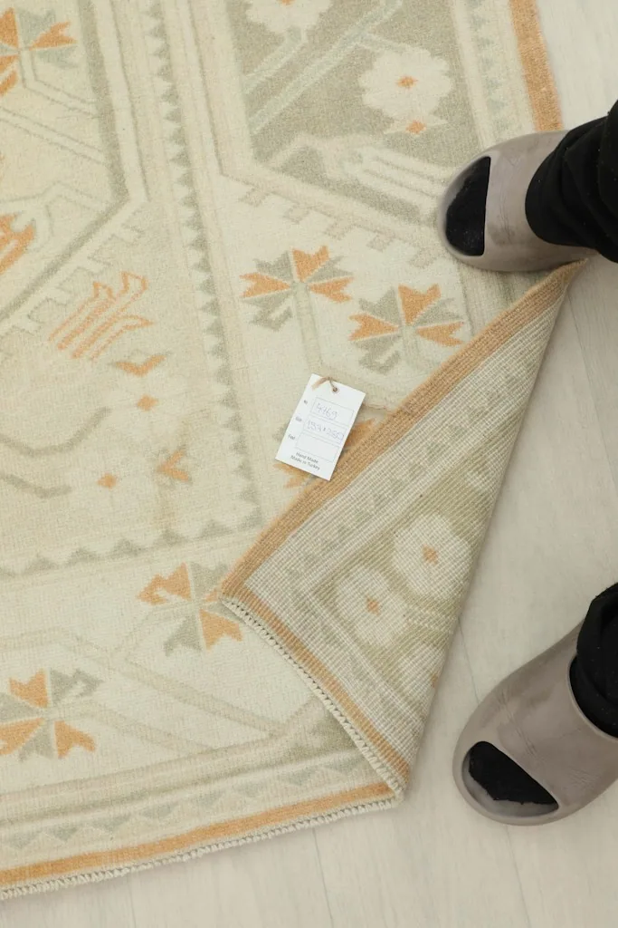 Close-up of the rug's low pile and fringe, with a foot for scale.