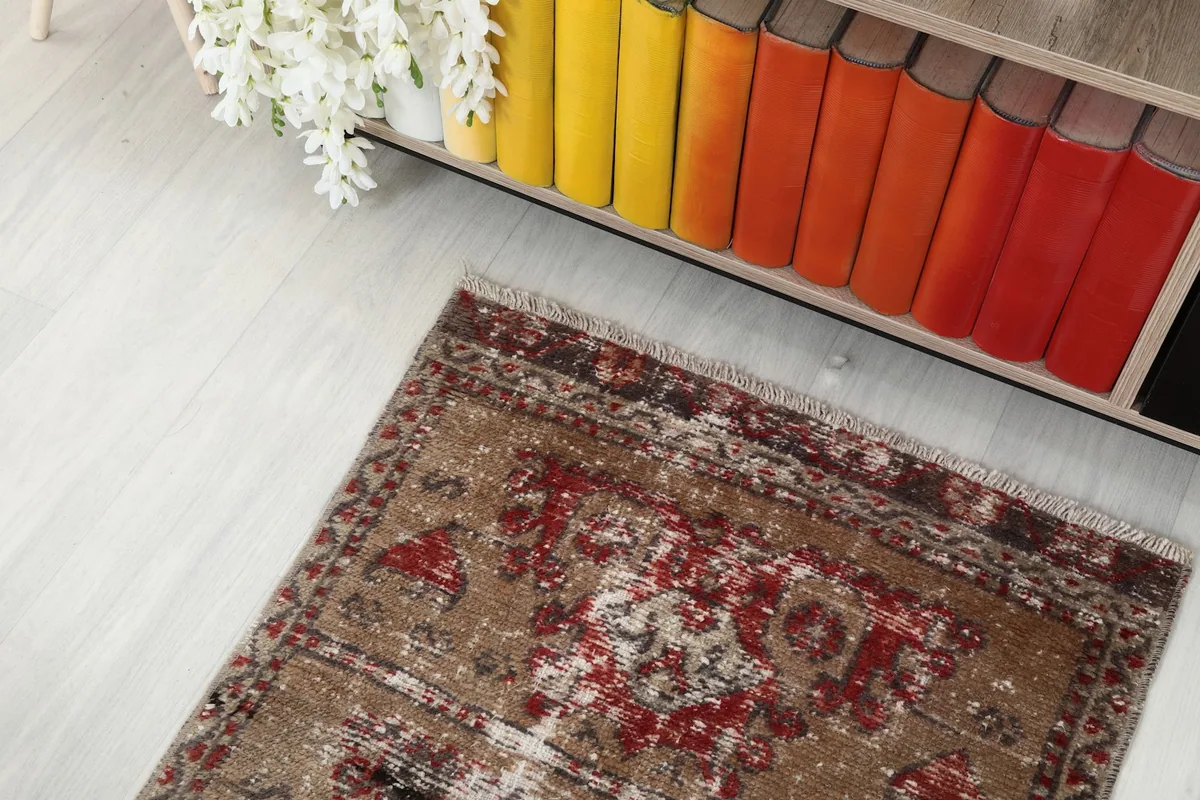 Overhead view of one end of the runner rug placed in a room with a colorful bookshelf.