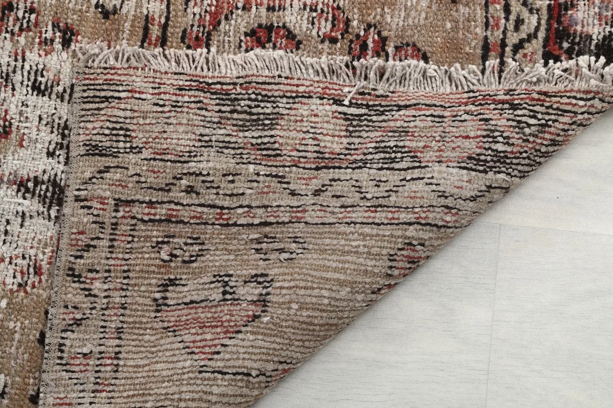 Underside view of the runner rug, revealing the tightly woven cotton foundation and short fringes.
