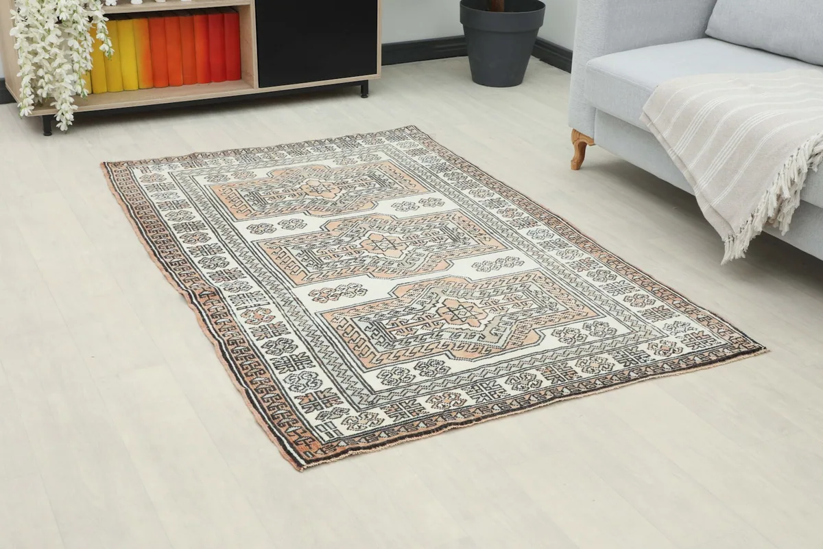 Angled view of the ivory and rust geometric rug on a light floor in a room