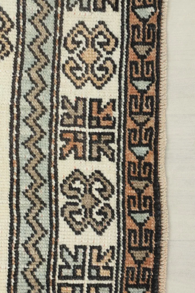 Detail of the rug's border, showcasing the various geometric and tribal elements