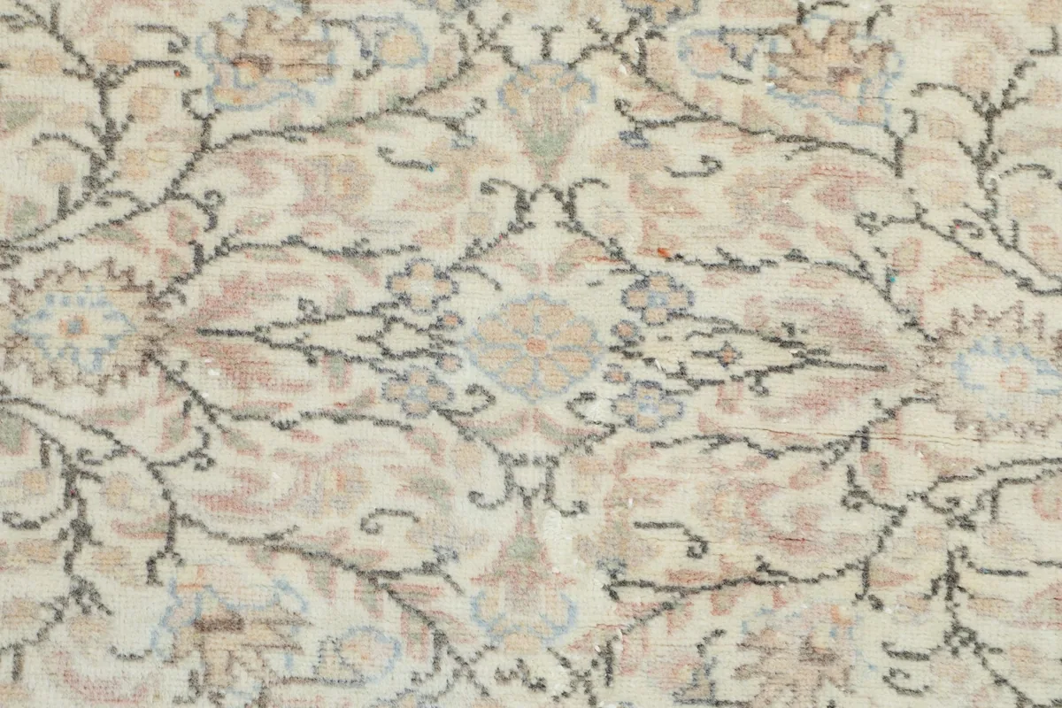 Detailed shot of the hand-knotted wool pile, showing individual rose and green floral elements