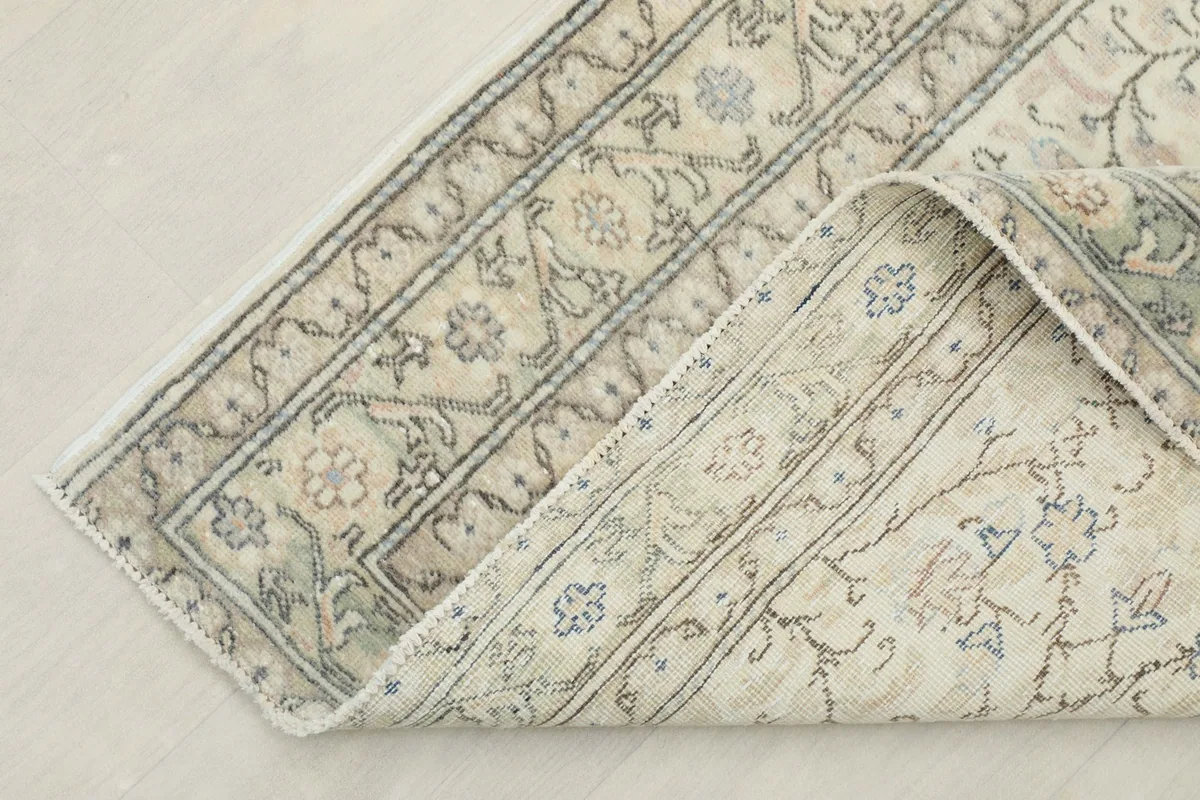 Corner of the rug folded back, showcasing the cotton foundation and the reverse side