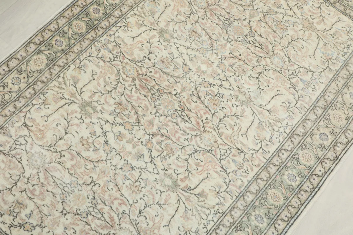 Overhead view focusing on the delicate floral motifs and color variations across the rug's surface