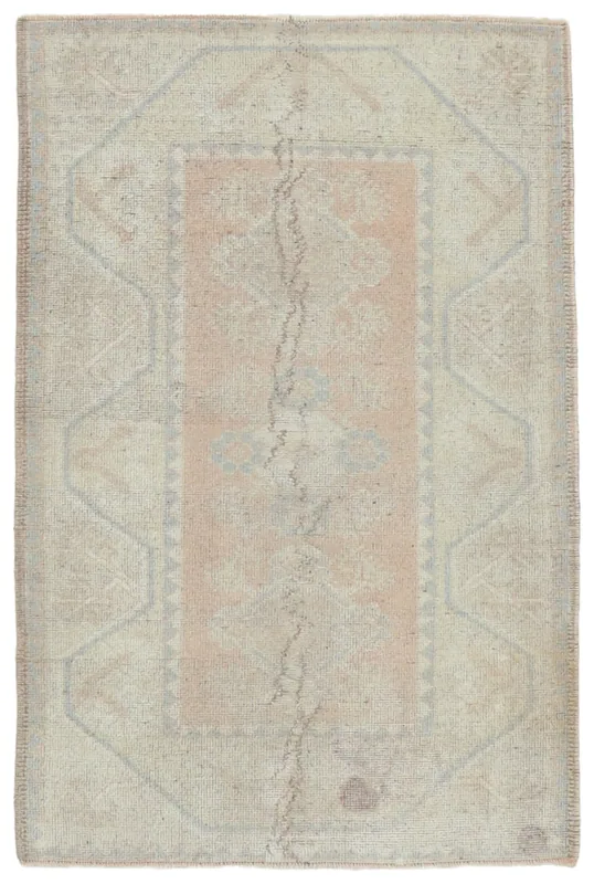 Full overhead view of the hand-knotted vintage Anatolian rug with rose field and beige geometric patterns