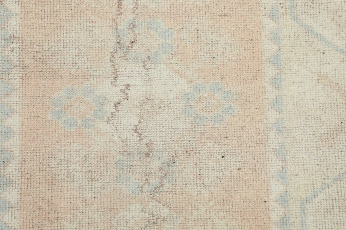 Close-up of the low wool pile, showing the texture and aged appearance of the vintage rug